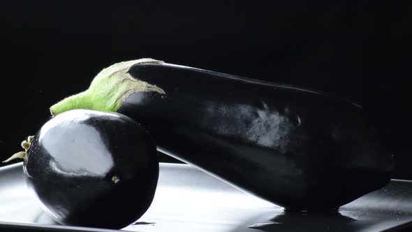 Natural Eggplants Gyrating on Black Background alt