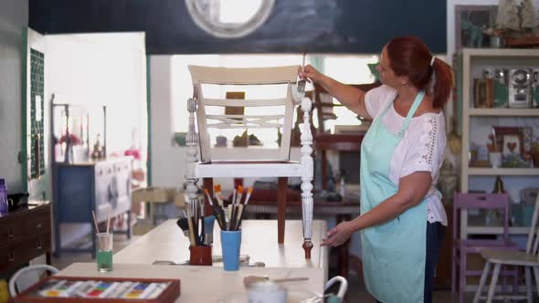 Mature Woman Repainting and Revamping Antique Chairs at Home