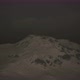Dramatic Dark Rocky Mountain with Patches of Snow in Storm