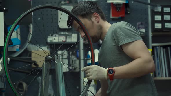 Professional Bicycle Mechanic Adjusting One Spoke at Time Special Tool for Tensioning Spokes alt