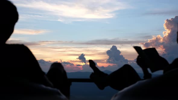 Silhouette of a couple sitting and watching sunset together