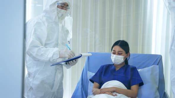 Covid19 Doctors in Ppe Suit with Face Mask Treating Young Woman Patient on Bed From Coronavirus alt