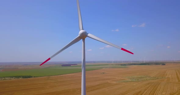Close Up of a Wind Turbine Spinning Over Farmers Fields