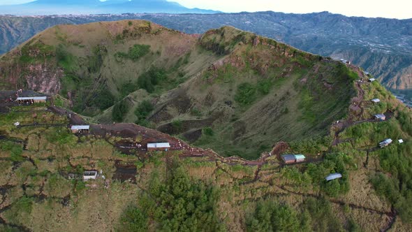 cafes along the crater rim and ridge of Mount Batur volcano in Bali Indonesia during sunrise, aerial alt