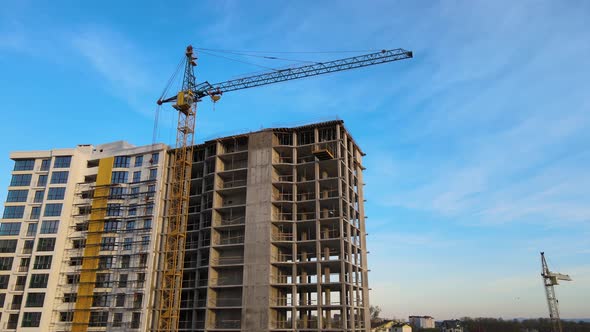 Tower Lifting Crane and High Residential Apartment Building with Monolithic Frame Under Construction alt