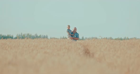 Dad with His Son Walking in the Field