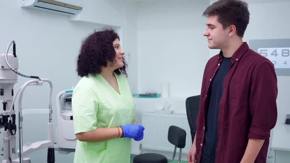 Side View Positive Patient and Doctor Shaking Hands Standing in Ophthalmological Hospital alt