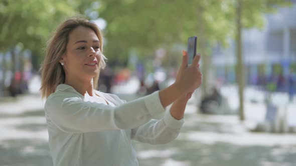Smiling Girl Having Video Chat Outdoor alt