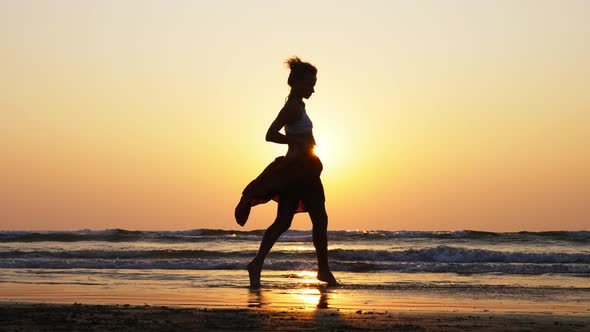 Silhouette of Young Girl Dancing at Sunset in Slow Motion alt
