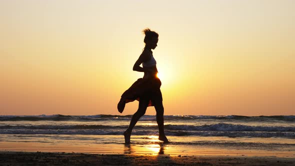 Silhouette of Young Girl Dancing at Sunset in Slow Motion