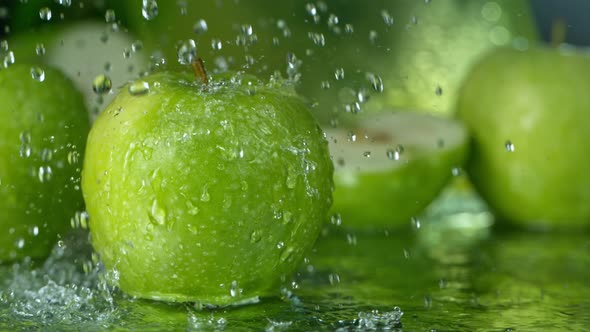 Super Slow Motion Shot of Water Splashing on Fresh Green Apple at 1000Fps alt