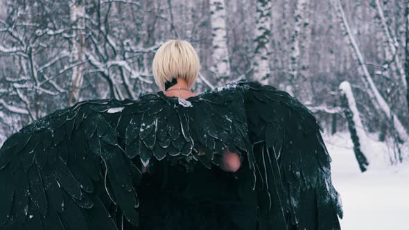 Actress in Wonderful Phoenix Suit Walks Along Winter Forest alt