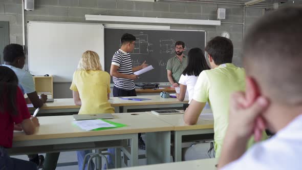 Latin American College Student Presenting a Project Reading a Composition to Classmates and Teacher alt