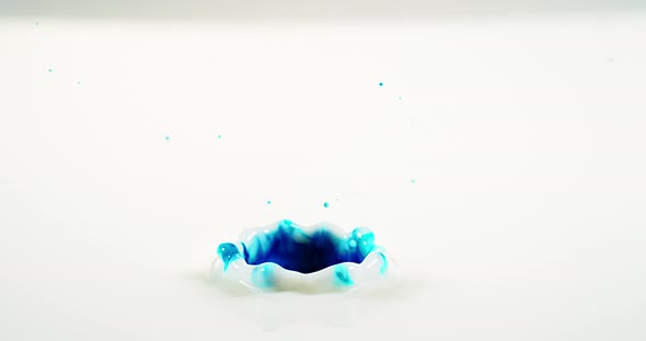 Blue Liquid falling into Water against White Background, Slow motion 4K alt