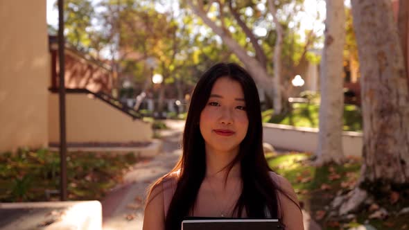 Asian female college student walking toward the camera alt