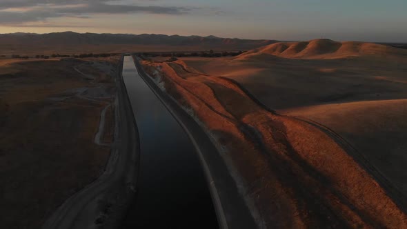 Rising aerial of the golden mountains and beautiful sunset shading Southern California. The life giv alt