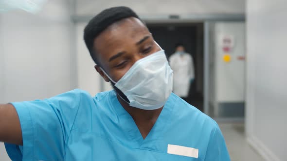 Portrait of Smiling African American Nurse at Work Walking in Corridor at Hospital alt