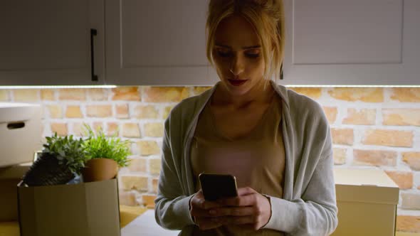 Video of helpless woman with phone while moving house. Shot with RED helium camera in 8K. alt