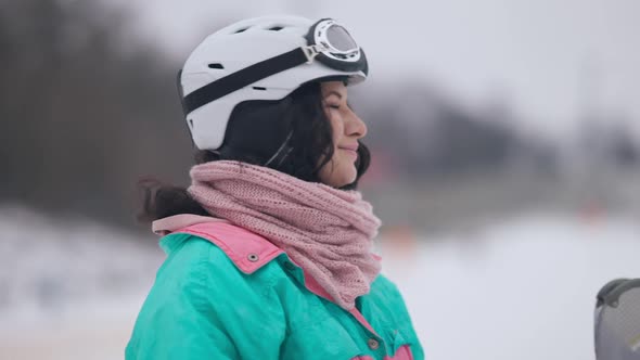 Portrait of Happy Relaxed Young Woman Standing on Snowy Ski Resort Breathing in and Out alt