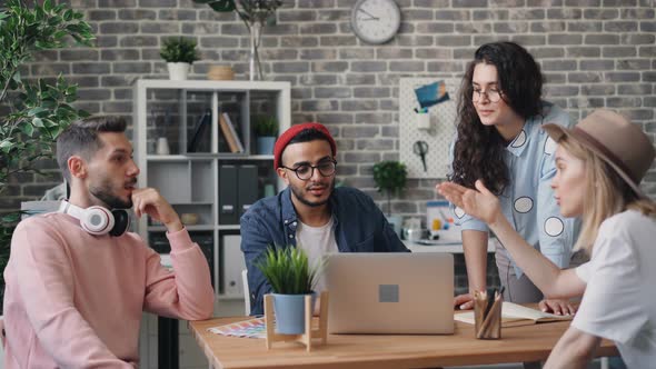 Creative Team Talking in Office Discussing Ideas Looking at Laptop Screen alt