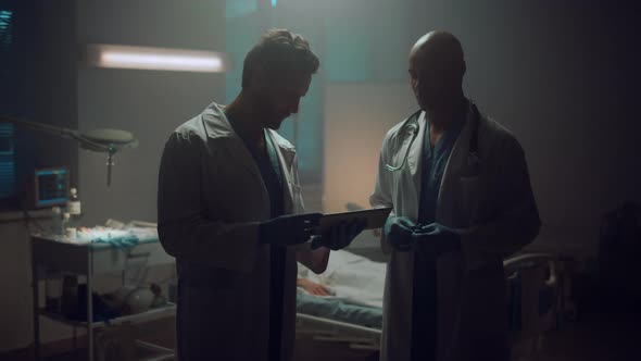 Portrait Two Doctors Meeting Holding Tablet Computer in Patient Hospital Room alt