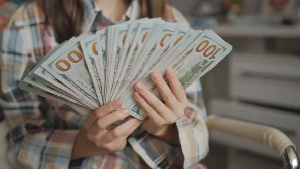 A Stack of Hundreddollar Bills in the Hands of a Teenage Girl
