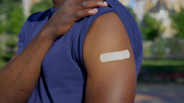 Afroamerican Man Patient Shows Medical Plaster Demonstrates Vaccine Injection alt