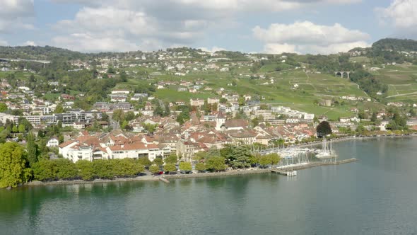 Fly by town of Lutry seen form Lake Léman (Lake Geneva) Summer colors and reflections in the water. alt