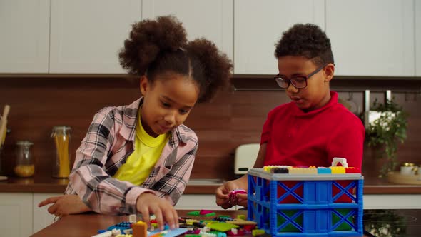Creative Preadolescent Black Children Constructing with Colorful Toy Blocks alt