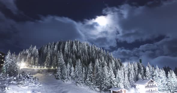 Snowy Mountain With Rolling Clouds Covering The Moon Against The Night Sky - Time Lapse alt