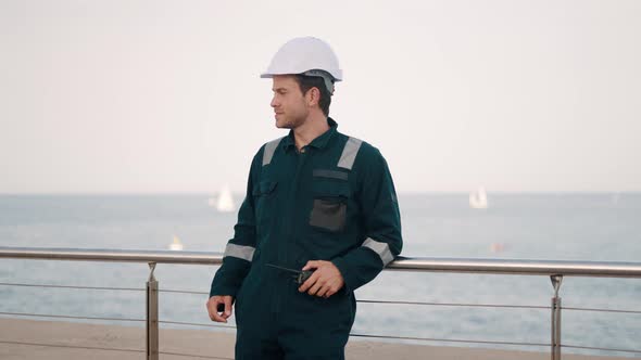 Port Worker Reporting About Status of Cargo By Walkie Talkie Radio While Working at Seaport alt