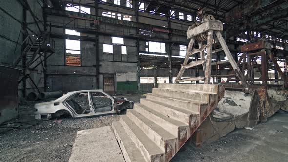 Old construction with stairs and antique car frame on the background of broken plant. alt