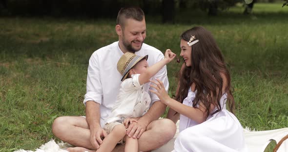 Woman in a Sundress Kissing Her Spouse and Son