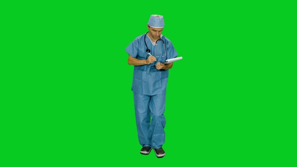 Doctor In Uniform Writing On Clipboard While Walking In Hospital