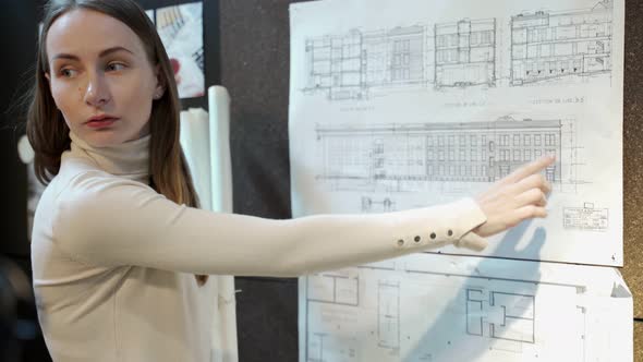 Female Architect Shows a Cottage Construction Project alt