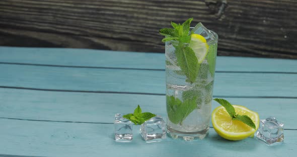 Clear Water in Glass with Green Mint Leaves and Ice Cubes alt