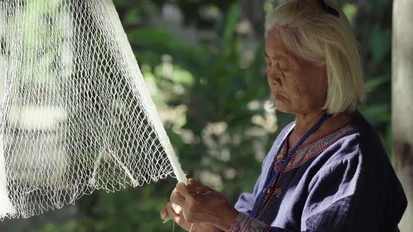 woman weaving a fishing nets.