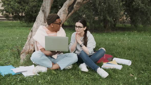 Male and Female Students Looking on the Laptop Screen Happily High Five Within International alt