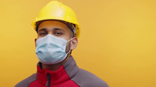 Portrait of Young Indian Man with Face Mask and Yellow Helmet Nodding ...