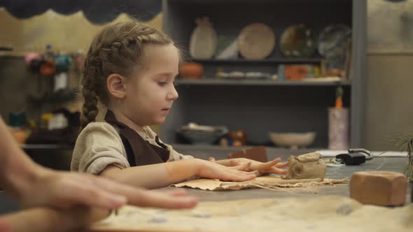A Young Potter Child Girl Sculpts From a Piece of White Clay a Blank for the Future Mug