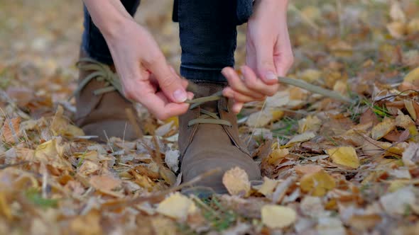 Female tying her shoelaces on her leather shoes alt