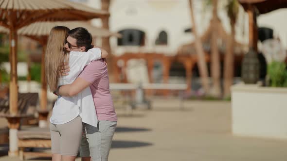 Embrace and Kiss of Loving Couple in Beach of Hotel in Summer alt