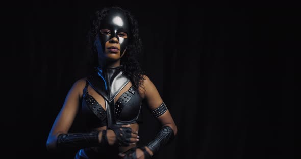 Beautiful Young Black Woman in Leather Outfit and Catwoman Mask Posing alt