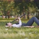 A Girl Plays the Clarinet While Lying on the Grass in the Park - VideoHive Item for Sale