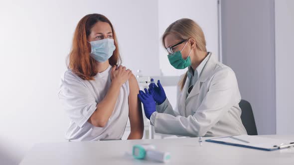 Woman Receiving Vaccine From Doctor