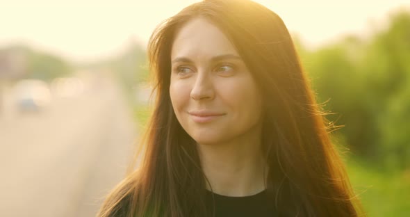 Young Beautiful Girl Looks Away From the Camera and Smiles alt