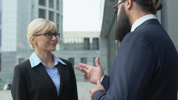 Smiling Female Office Worker Listening to Boss Outside Building, Private Chat