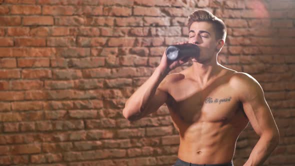 Muscular Young Man After a Workout Drinking Bottle of Water