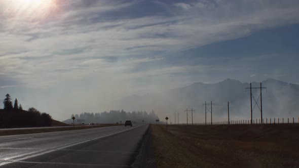 Highway with smoke from fire close to mountains alt