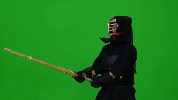 Masculine Kendo Warrior Practicing Martial Art with the Bamboo Bokken on Green Screen. CLose Up alt
